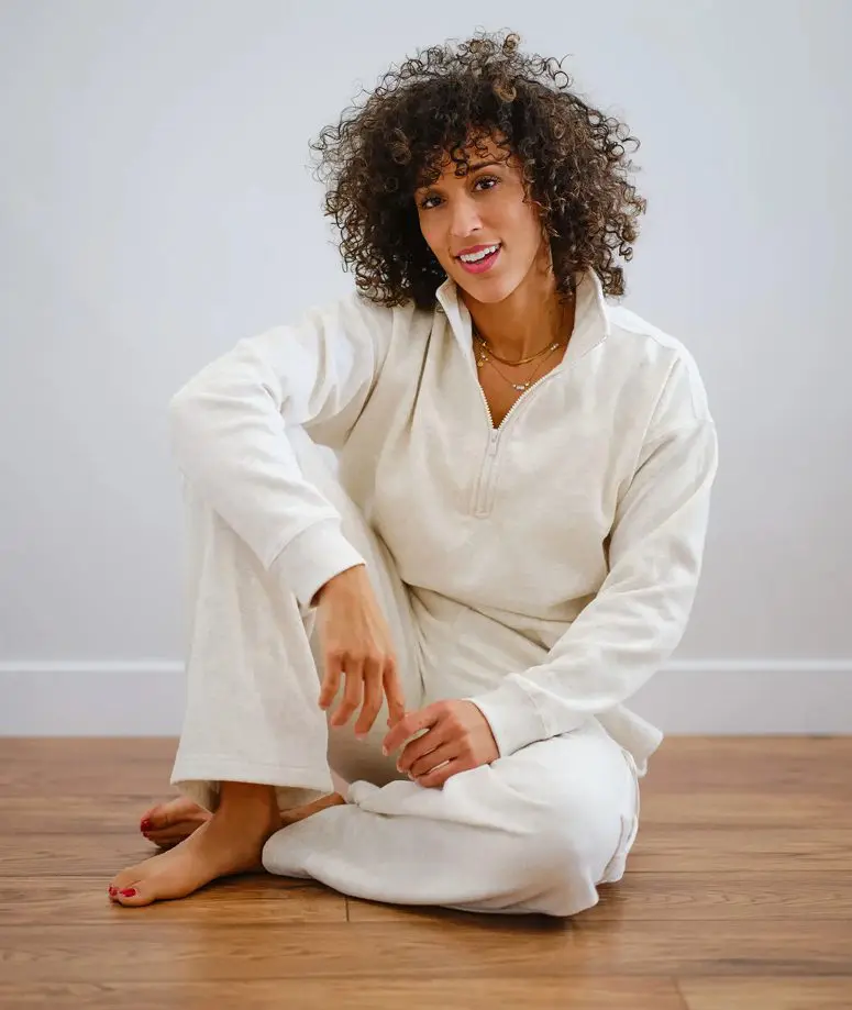 Woman sitting in white outfit indoors
